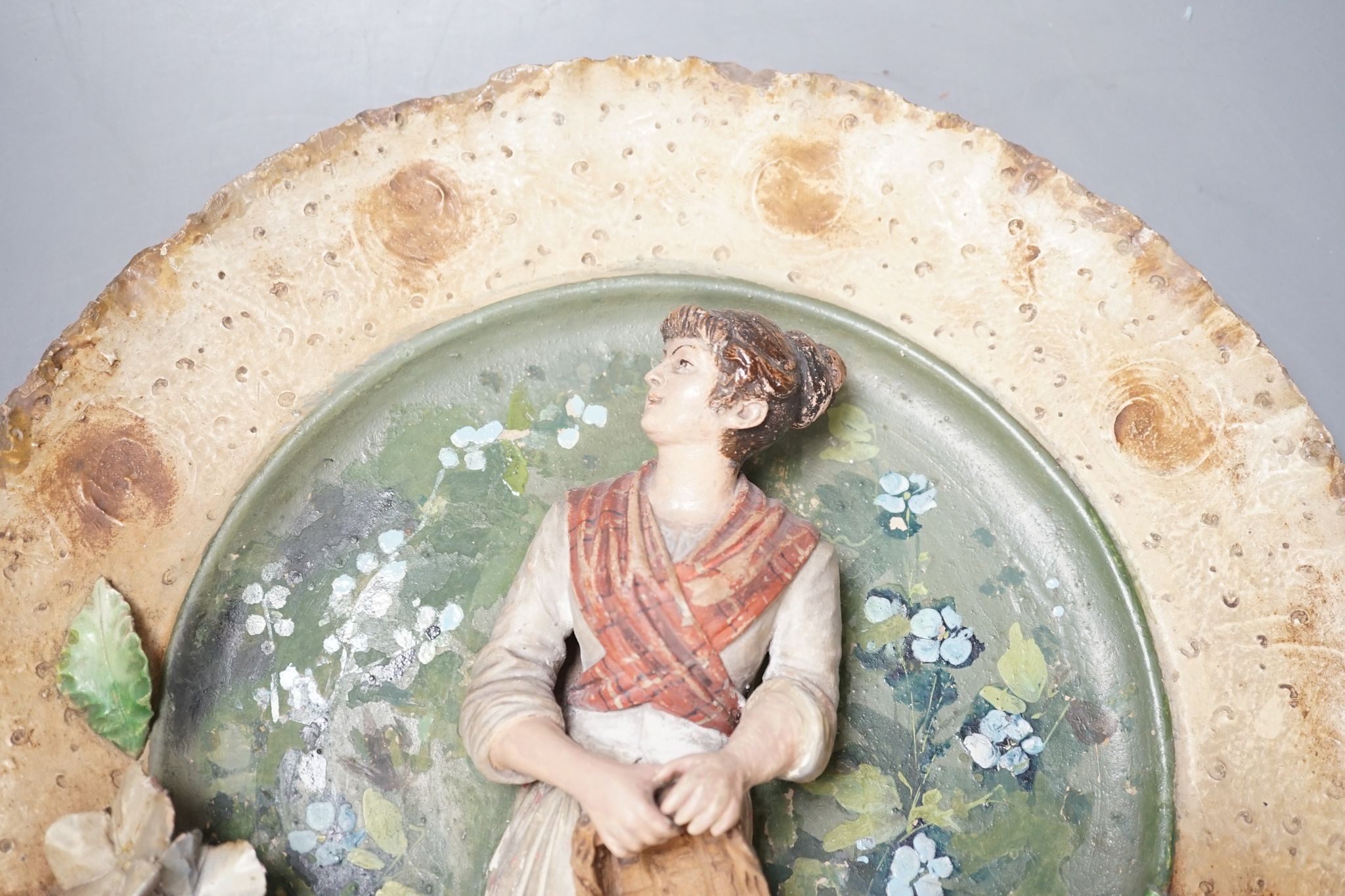 A Continental terracotta wall plaque and a Poutney & Co plaque (2) 39cm
